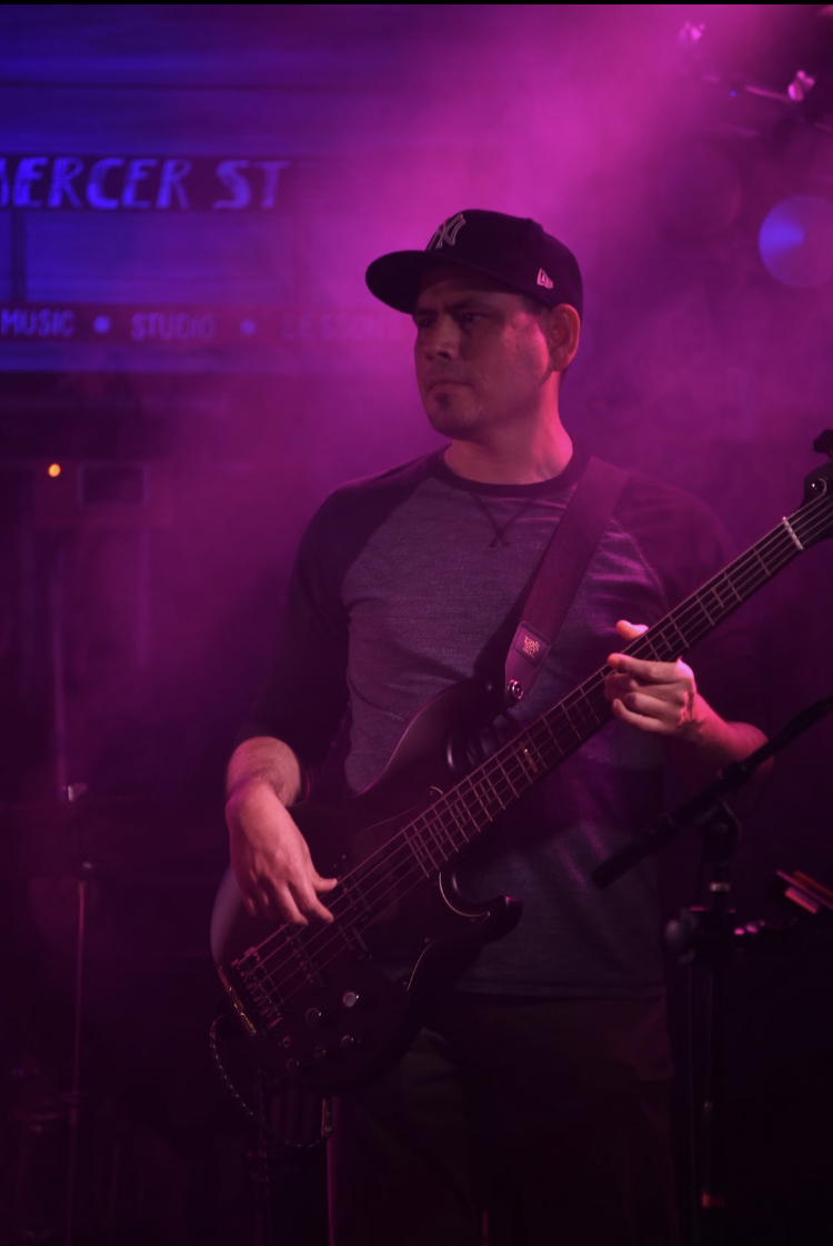 A picture of me playing a black bass guitar